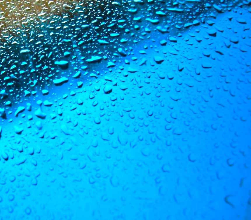 Photo: raindrops, scattered across a bright blue surface, a little gold-shaded triangle in the upper left-hand corner, image by Bill Taft, on Pixabay, modified.