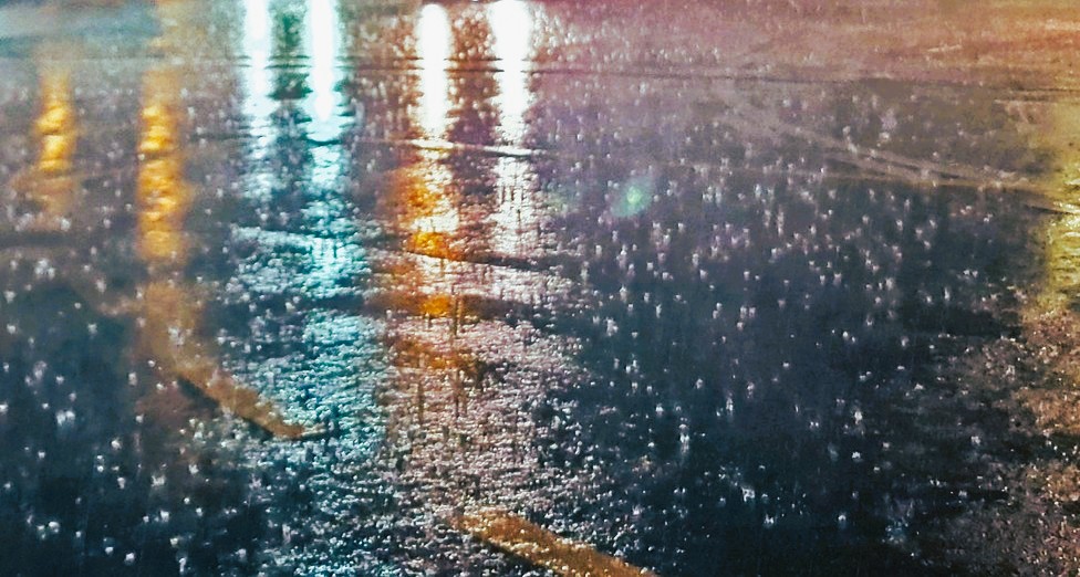 Photo: rainy street at night, yellow, green, and white lights reflecting on wet pavement, image by adege, on Pixabay, modified.